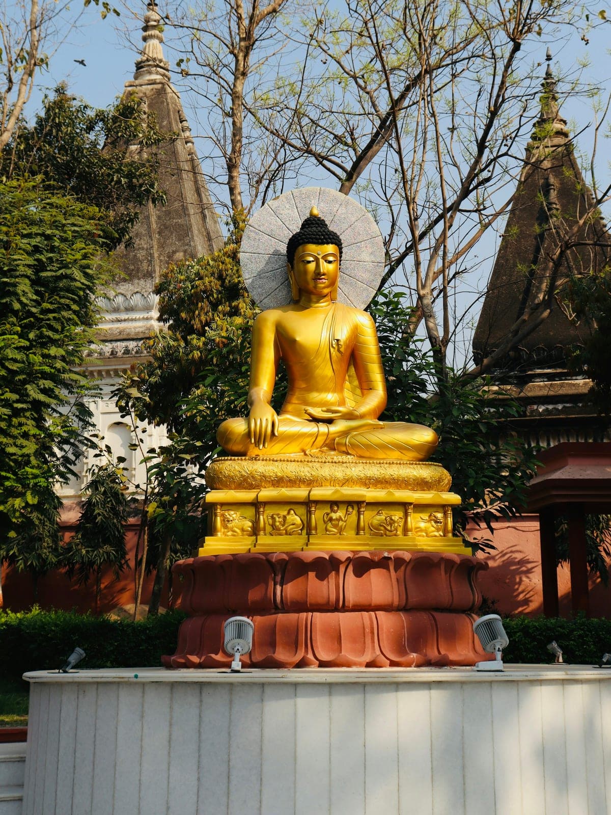 The gilded Buddha at Bodh Gaya, with the Mahabodhi temple spires behind it